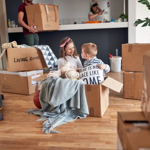 brother-and-sister-playing-in-empty-cardboard-box-move-picture-id1344286727